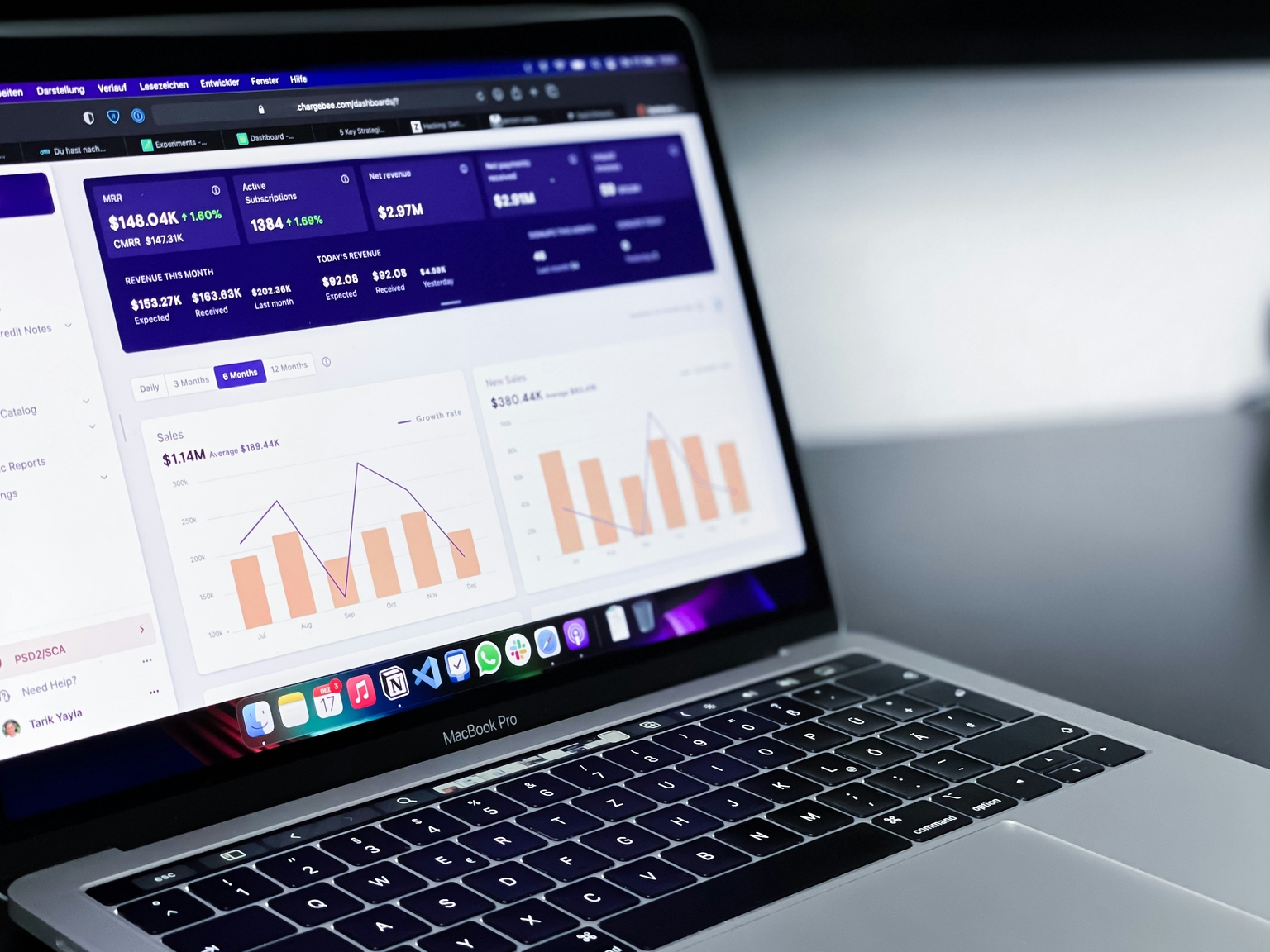 A macbook and on the screen a dashboard with statistics.